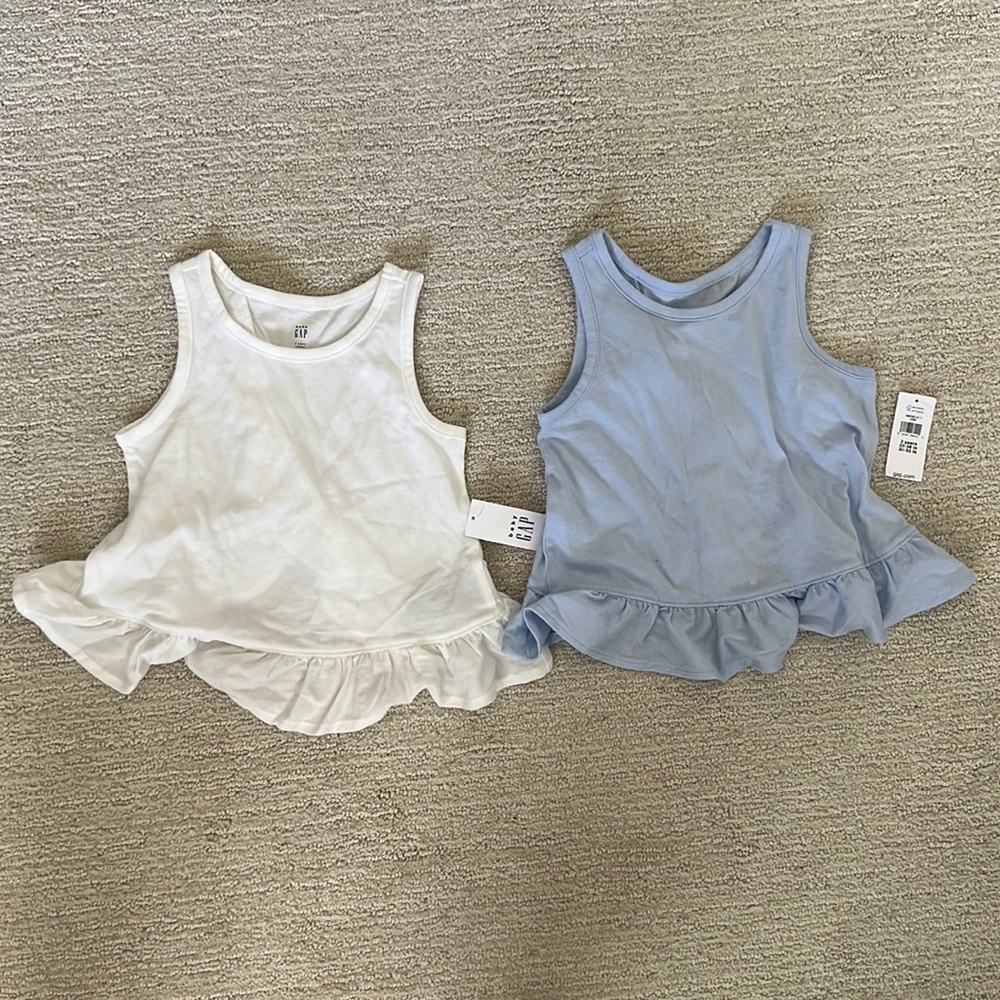 Size 2T NWT peplum/ruffle bottom tank tops in white and baby blue.